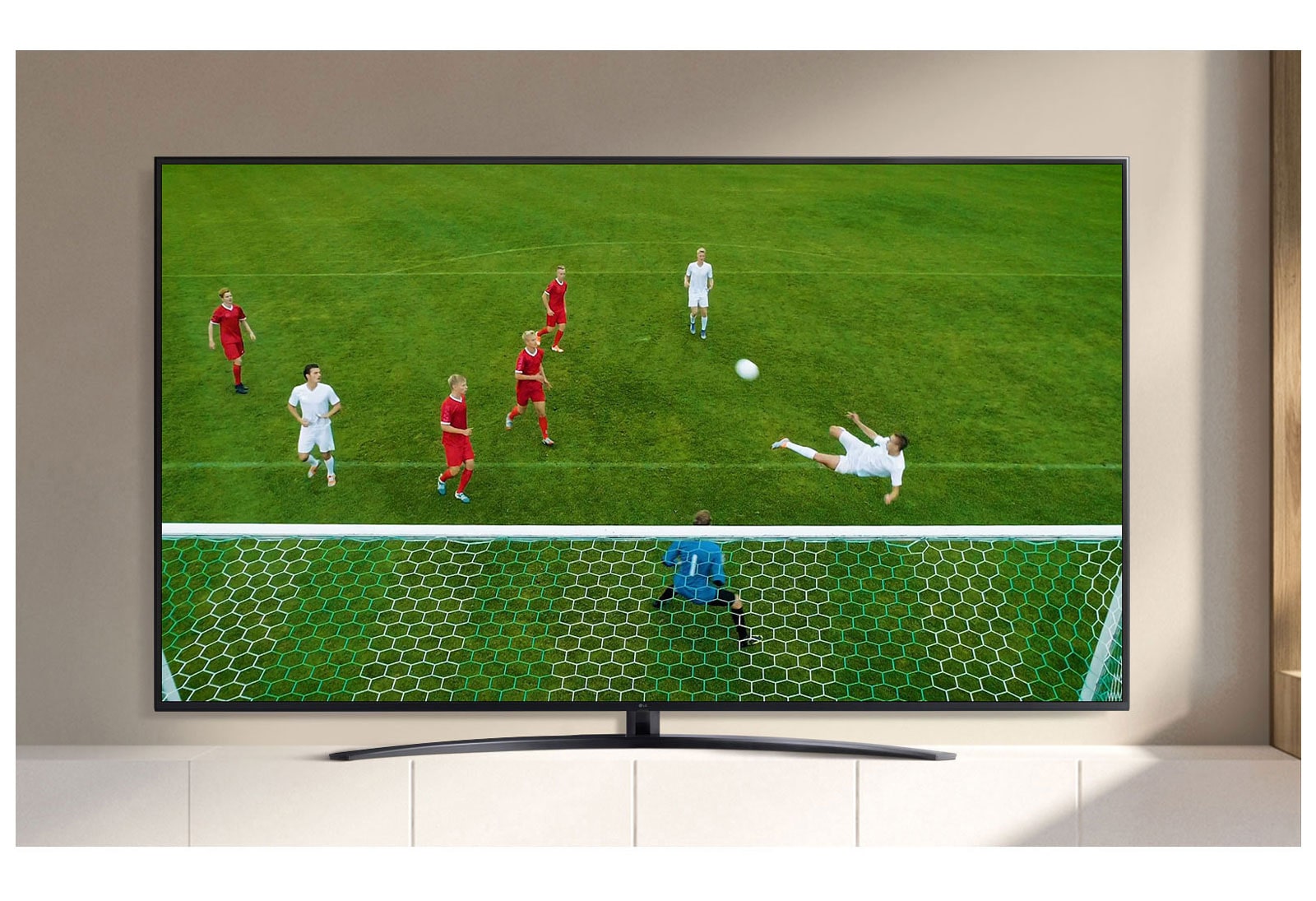 A TV screen playing a video of a soccer player making a goal during a soccer game. (play the video)