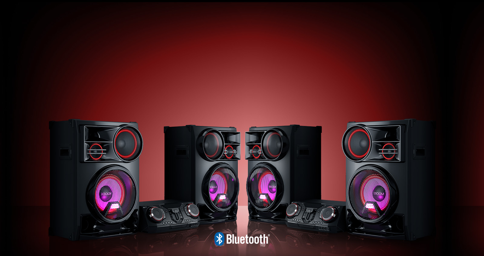 La imagen muestra un fondo rojo viñetado. Dos sistemas LG XBOOM CL98 se colocan sobre el suelo reflectante, uno frente al otro.