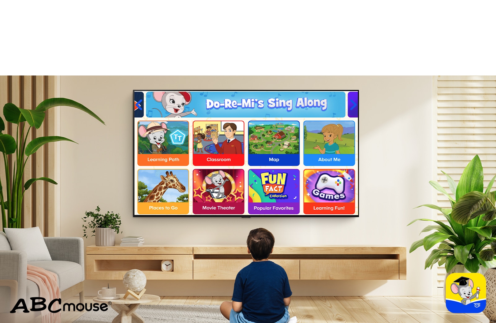 Un niño pequeño se sienta en el suelo y mira contenido educativo en ABCmouse. 
