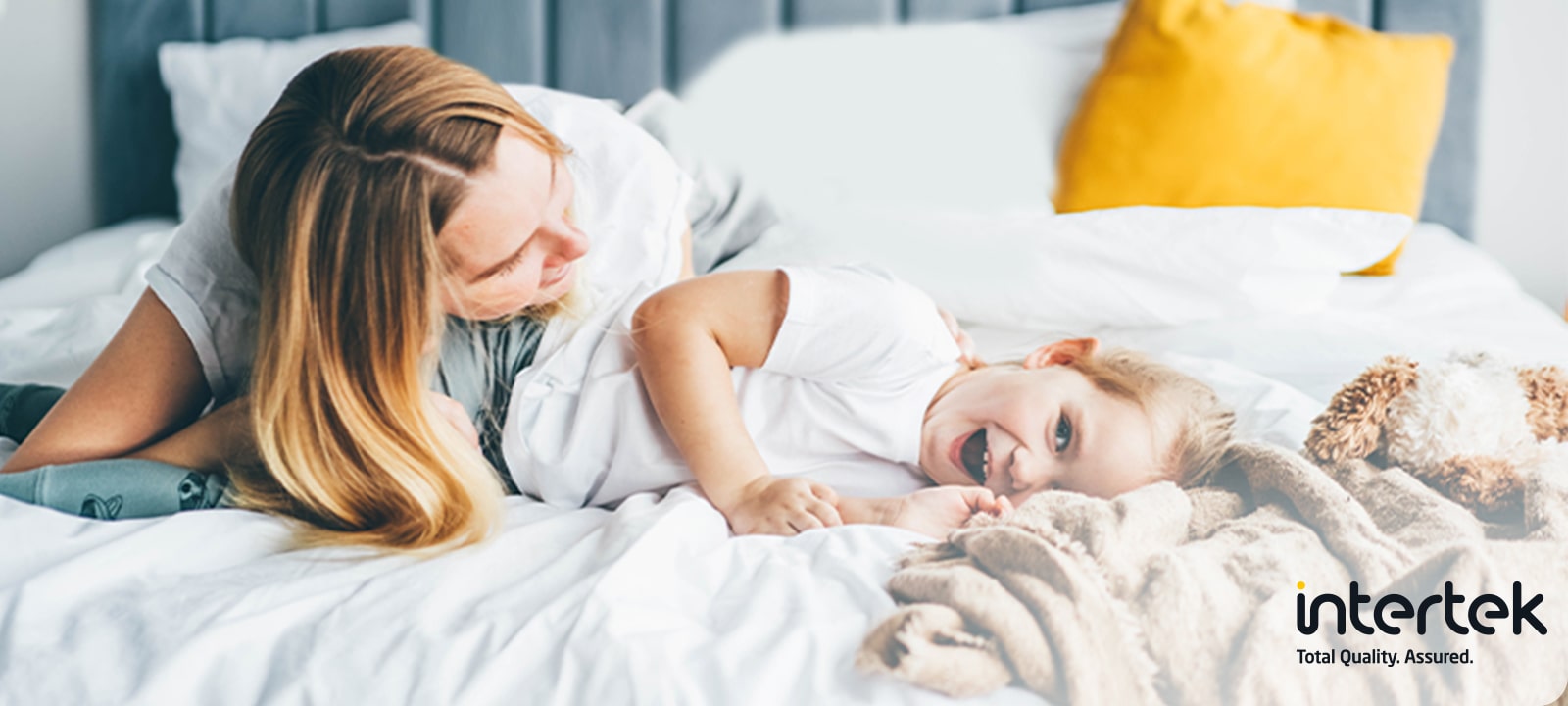 Una mujer y un niño están acostados en la cama sonriendo