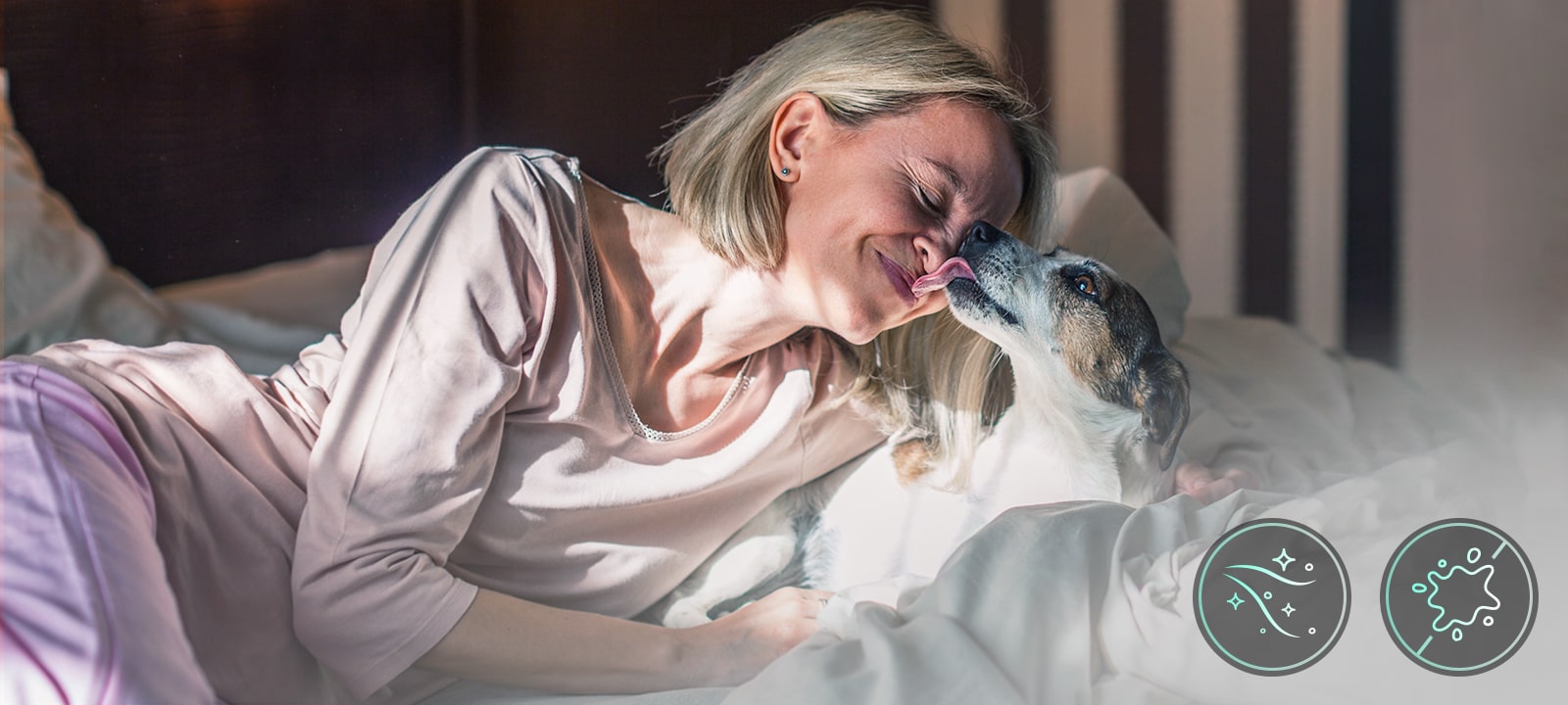 Una mujer y un perrito acostados en una cama
