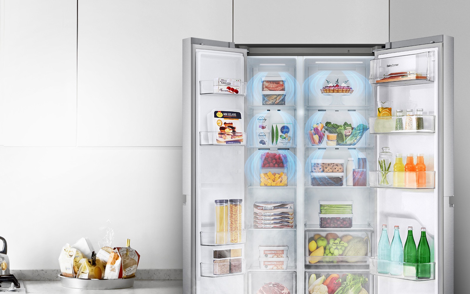 A front view of the refrigerator with the two front doors wide open showing a full refrigerator. Blue clouds of fog are shown falling over all products.