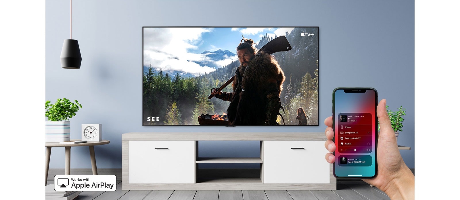 Primer plano del control manual de TV con iPhone y TV que muestra un contenido de Apple TV+
