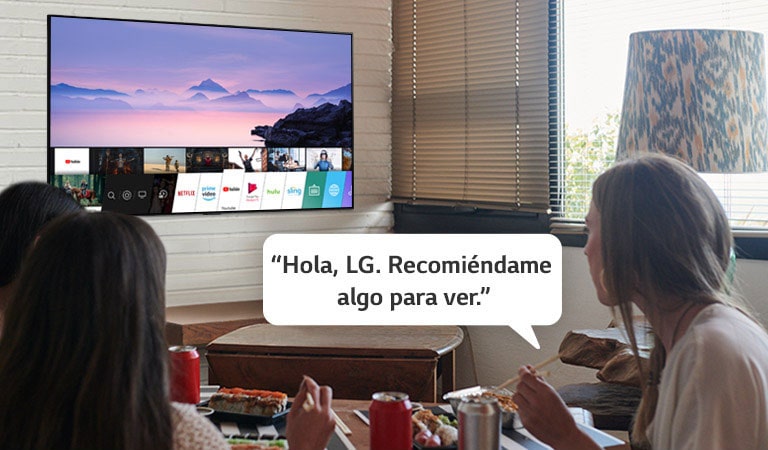 alt="Tres mujeres comiendo sushi mientras una de ellas le pide recomendaciones a la TV LG"
