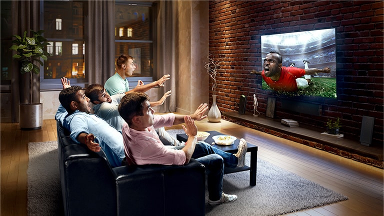 Esta tarjeta describe el virtual surround plus. Una familia sentada en un sofá viendo fútbol en la televisión.