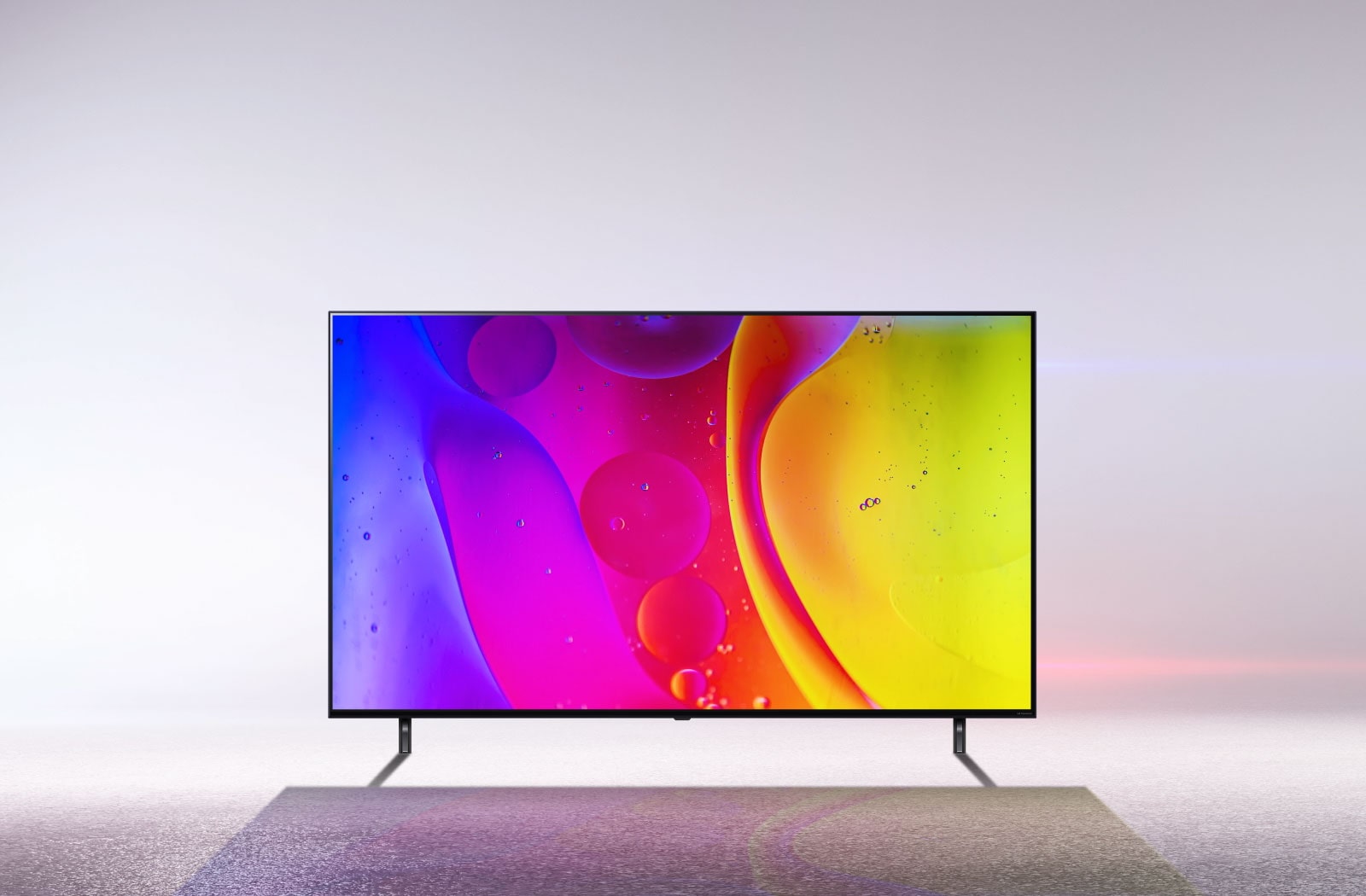 Un televisor en una habitación completamente blanca muestra colores brillantes e hipnóticos en movimiento en la pantalla.