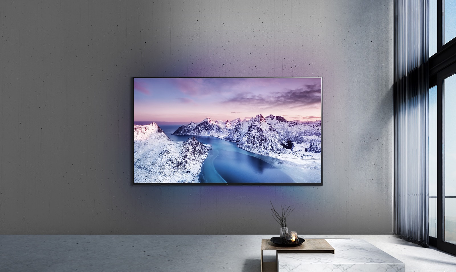 Un televisor UHD montado en la pared detrás de una mesa con ambientación de estilo zen.