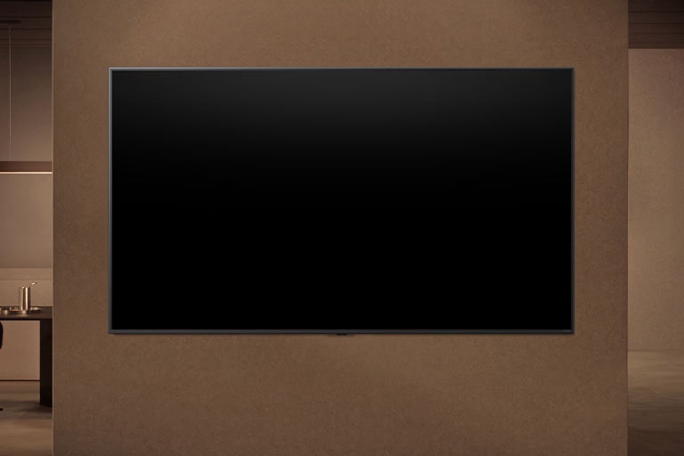 Una LG TV wall-mounted con la pantalla apagada muestra cómo los sensores de movimiento de la TV pueden ajustarse de forma inteligente en función del movimiento detectado cerca.