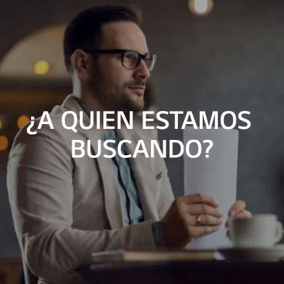 Un hombre sentado en un escritorio sosteniendo una pila de papel