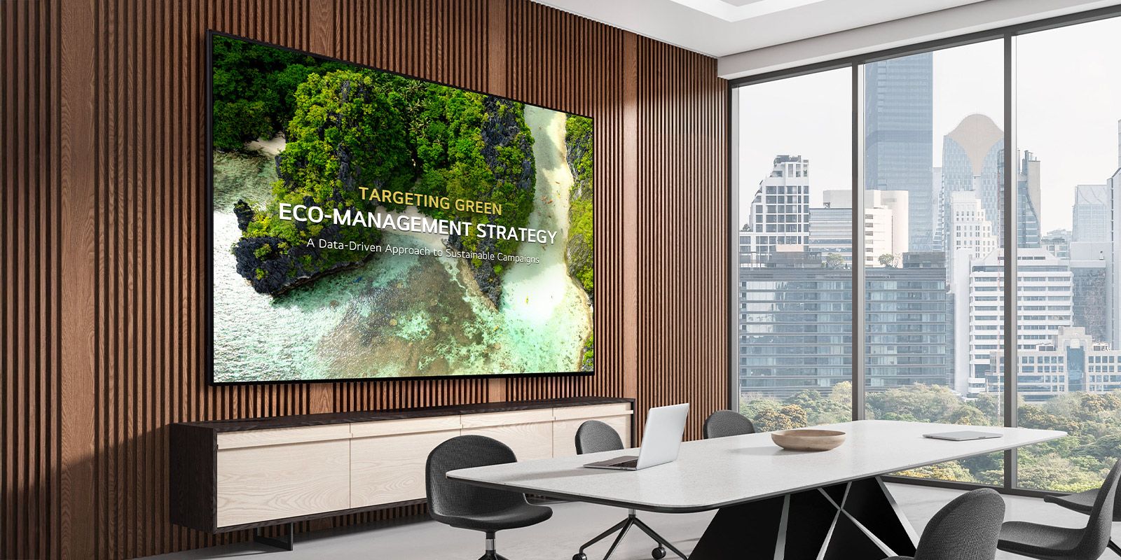 A signage display is mounted on the wall of a meeting room, clearly showing meeting content on the screen.