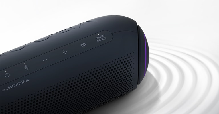 Sobre un fondo blanco, el LG XBOOM Go está en posición vertical y hacia arriba con iluminación morada; hay un efecto de ondulación debajo del aparato.