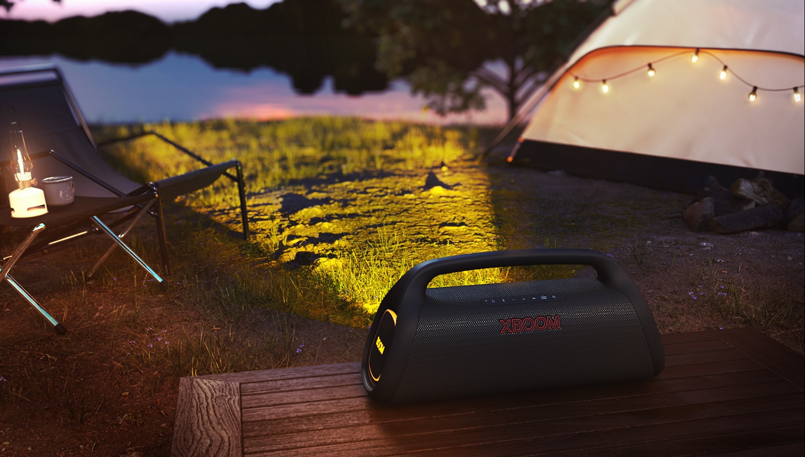 O LG XBOOM GO XG9 está colocado em um deck de madeira. Ele projeta a iluminação cênica no acampamento.