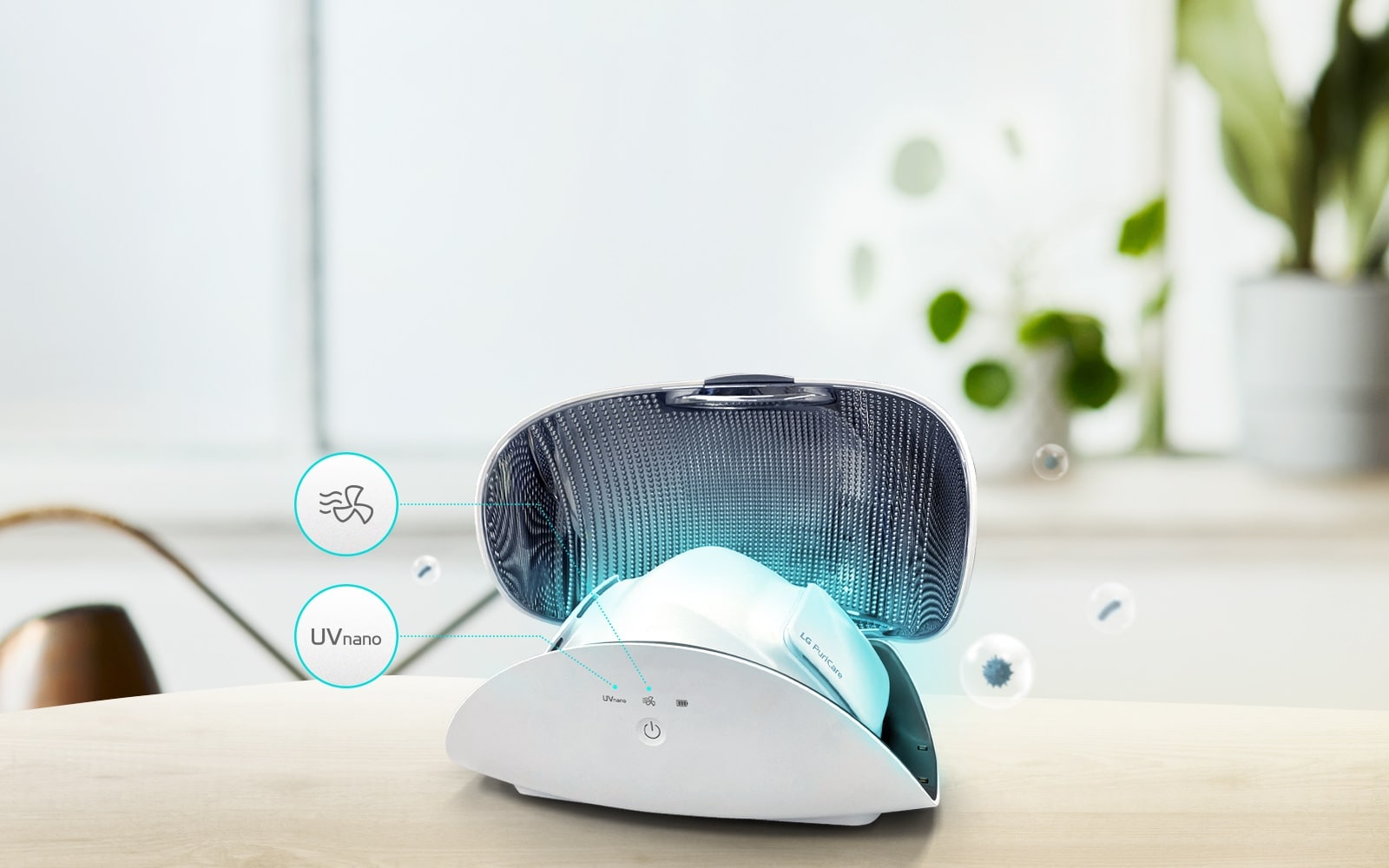 El purificador de aire facial se muestra dentro del estuche para purificador de aire facial sobre una mesa en la parte de adelante de la escena. La mascarilla emite una luz azul claro. Se muestran sobre el estuche el icono de Uvnano, el de secado automático y el botón de encendido.