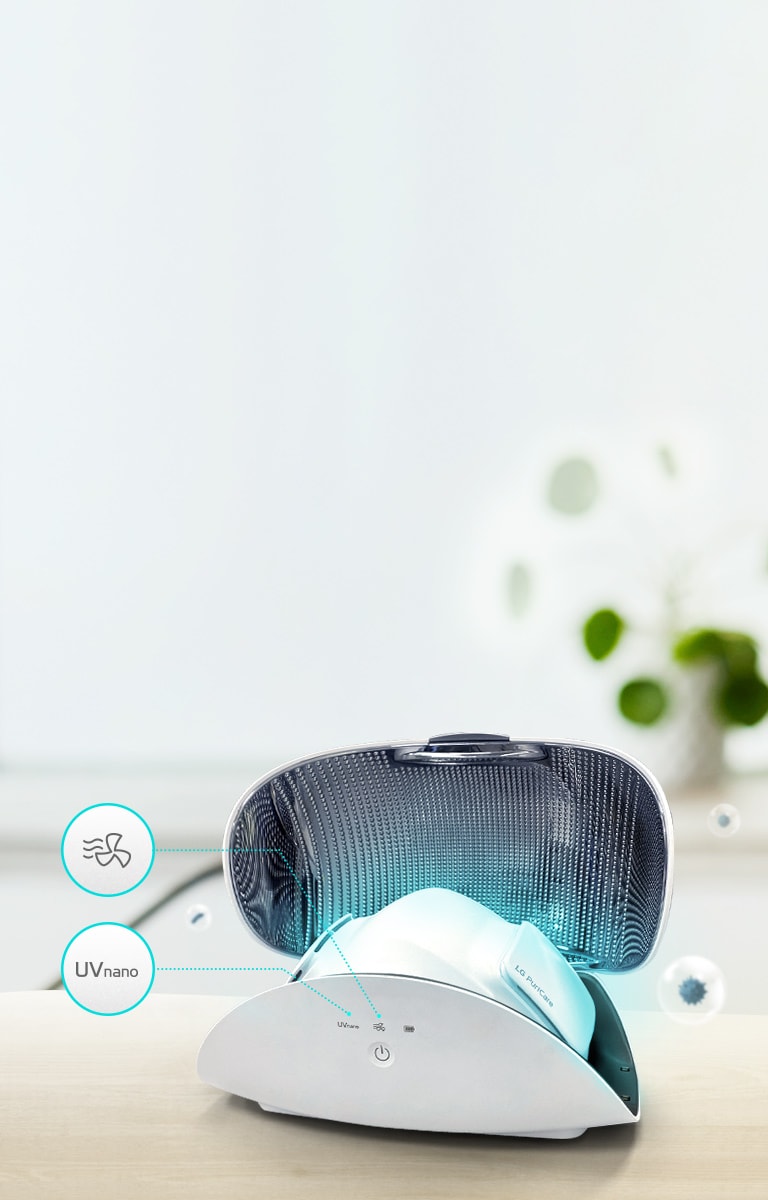 El purificador de aire facial se muestra dentro del estuche para purificador de aire facial sobre una mesa en la parte de adelante de la escena. La mascarilla emite una luz azul claro. Se muestran sobre el estuche el icono de Uvnano, el de secado automático y el botón de encendido.