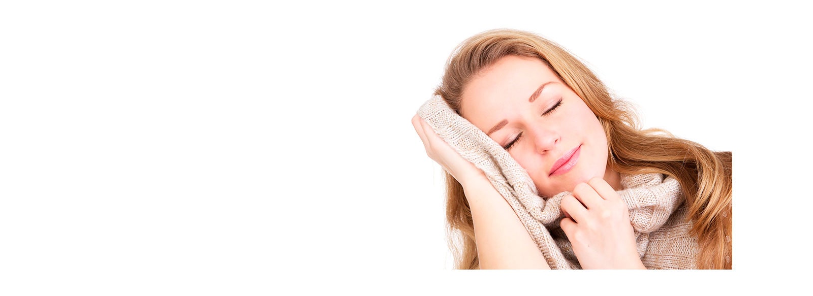 Una mujer con los ojos cerrados se pone un suéter en la cara.