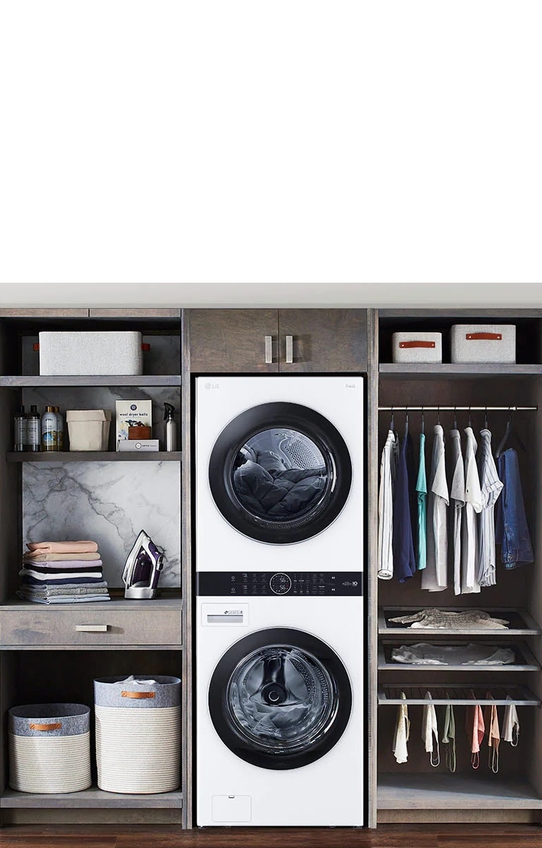 Una Torre de Lavado LG negra se instala en una lavandería, y una mujer se inclina para apretar un botón de la máquina.