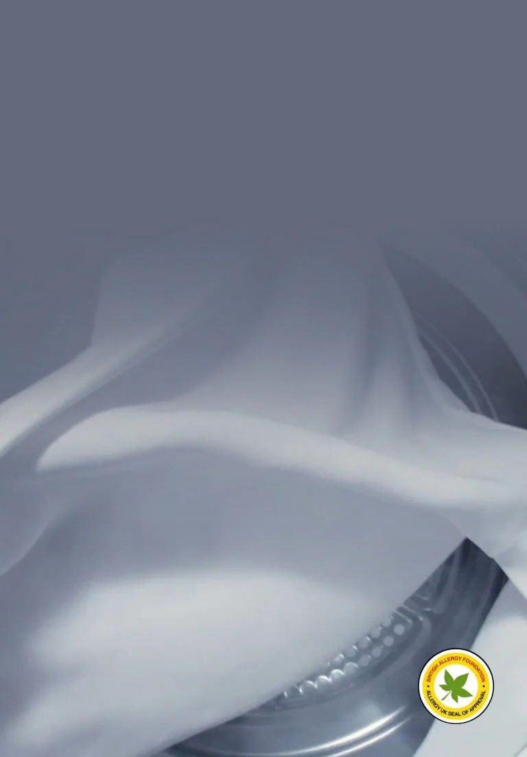 Se ve una prenda blanca con vapor alrededor. El logo certificado libre de alérgenos está en la esquina inferior derecha.