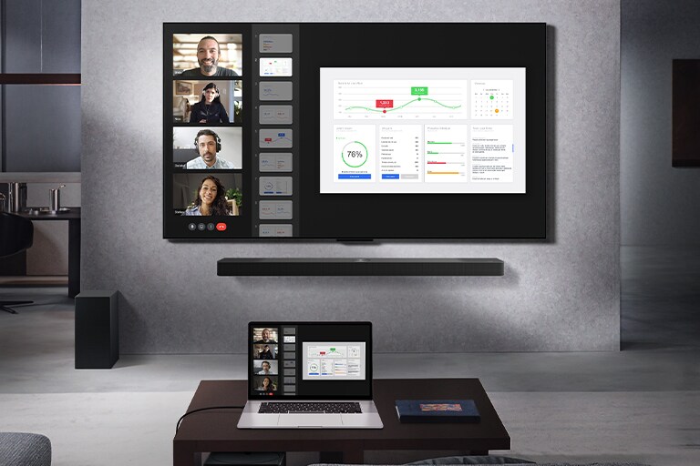 Una sala de estar desde la que se ve el sofá, frente a una LG True Wireless TV y una LG Soundbar montadas en la pared. En la mesa ratona, hay una computadora portátil conectada a la Caja de conexión cero que apenas se puede ver debajo de la mesa. La pantalla de la computadora portátil, en la que se ve una videollamada en directo, se proyecta de forma inalámbrica en la pantalla de la TV. El espacio está prolijo y sin desorden de cables a la vista.