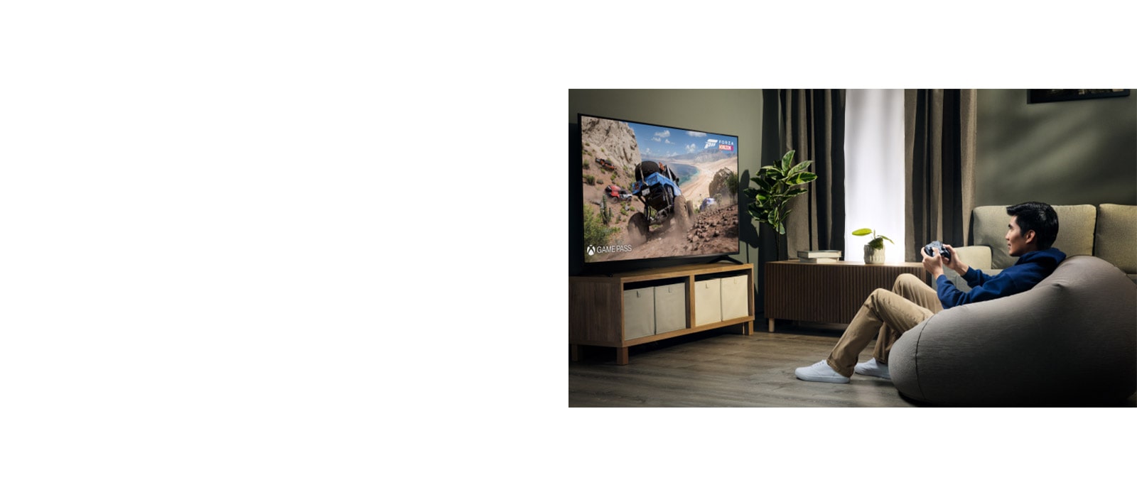 Una persona sentada en un puf juega un juego de carreras en un televisor grande usando el controlador Bluetooth LG Razer Wolverine, con una planta visible cerca en una acogedora sala de estar.