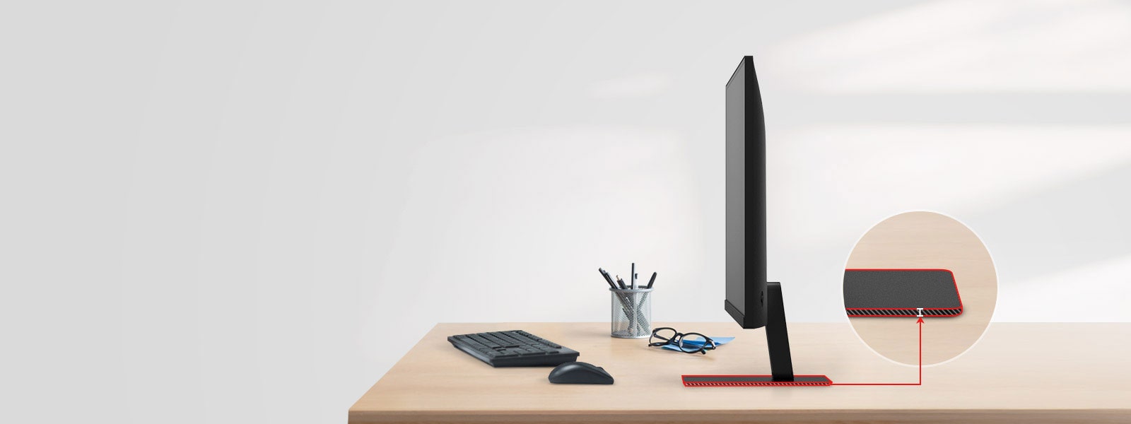 A QHD monitor with a super slim stand is on the desk, with a pencil holder, glasses, a keyboard, and a mouse next to it.