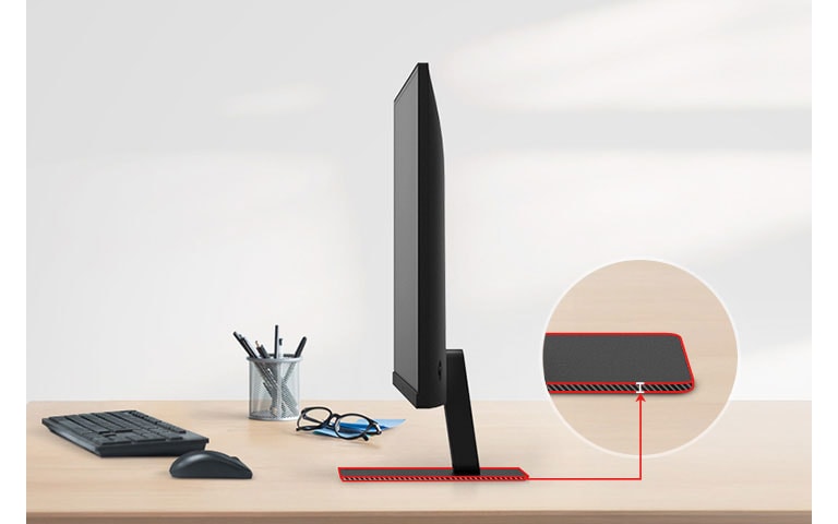 A QHD monitor with a super slim stand is on the desk, with a pencil holder, glasses, a keyboard, and a mouse next to it.