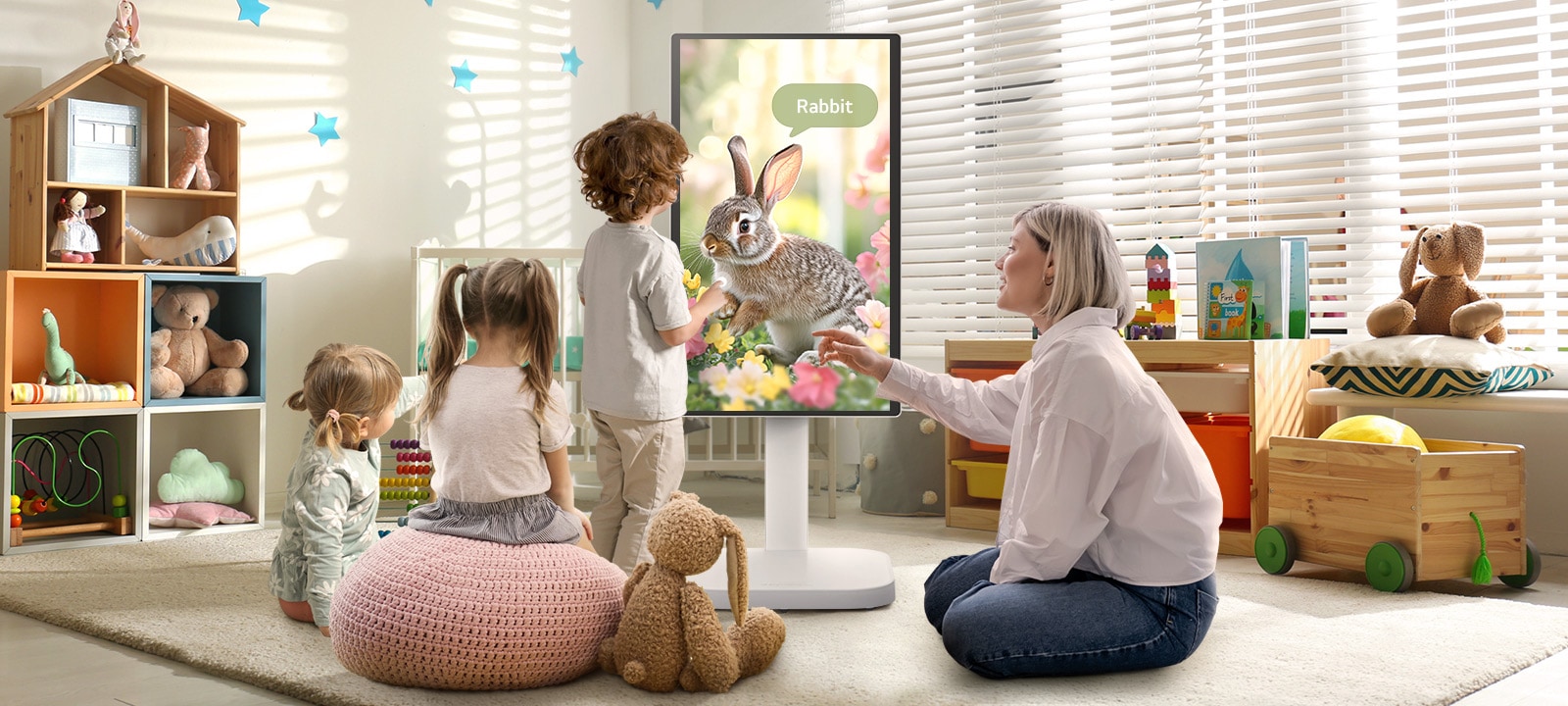 Esta imagen muestra a una mujer y tres niños jugando usando un LG Smart Monitor Swing.