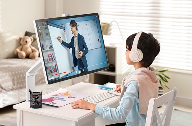 Un niño está viendo una clase en línea en un LG Smart Monitor Swing en una habitación.