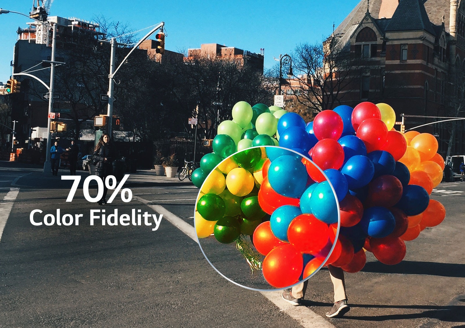 Una parte de un montón de globos de colores que un hombre sujeta mientras cruza el paso de peatones se agranda para mostrar el efecto de la fidelidad del color. (reproducir el vídeo)