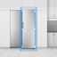 Vista frontal del refrigerador en una cocina, con un cuadrado azul y flechas mostrando su ajuste perfecto.