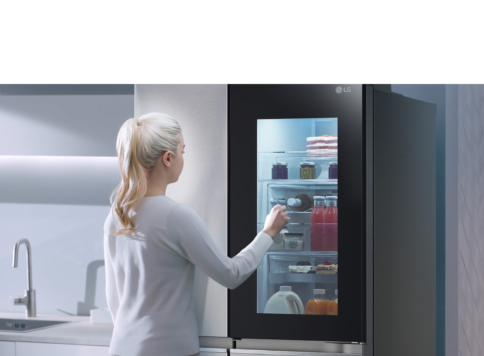 Un video muestra a una mujer tocando dos veces su refrigerador InstaView, iluminando el interior para ver y sacar una bebida.