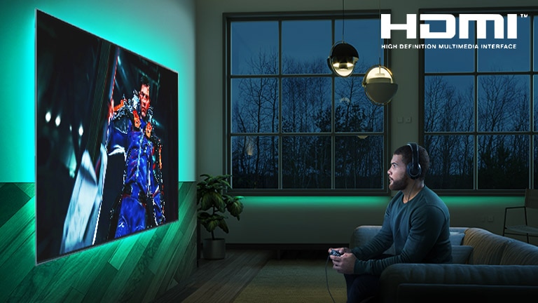 Un hombre sentado en un sofá, sujetando un joystick mientras juega una partida de un juego RPG en una pantalla de TV