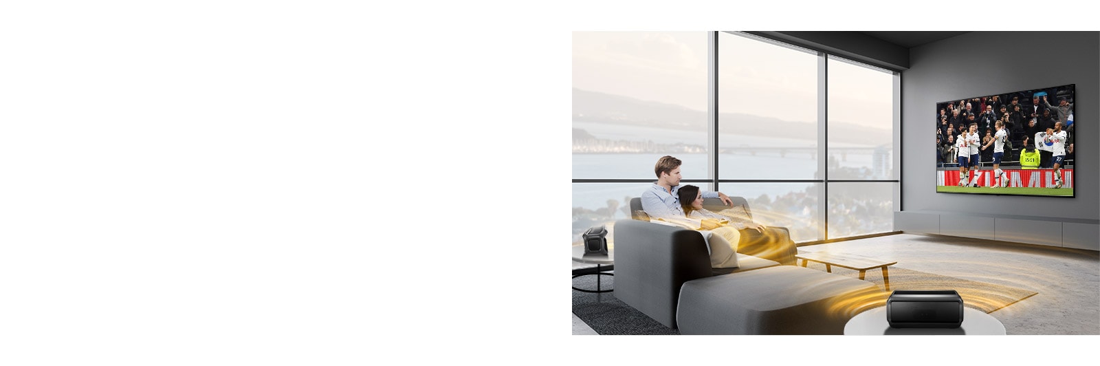 Un hombre y una mujer mirando deporte en el televisor del salón con unos altavoces Bluetooth traseros