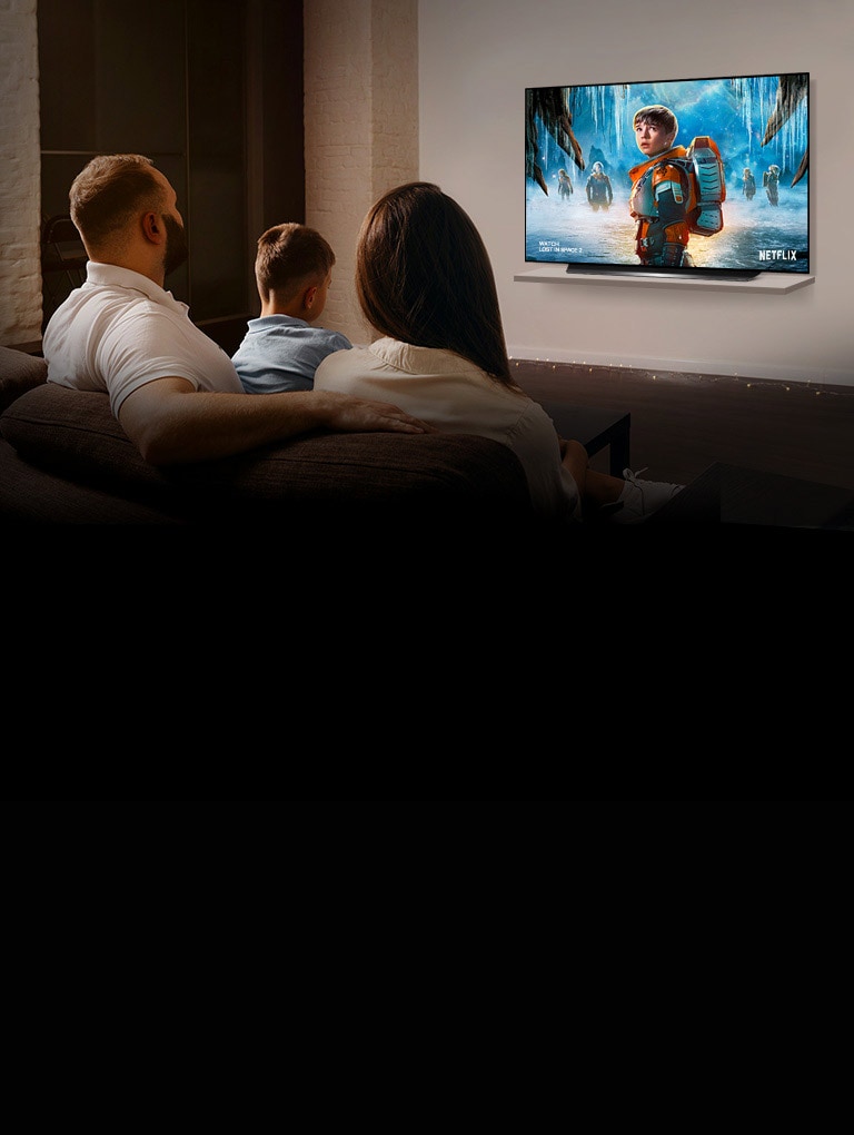 Pareja sentada en un sofá en la sala de estar mirando una película romántica en la TV