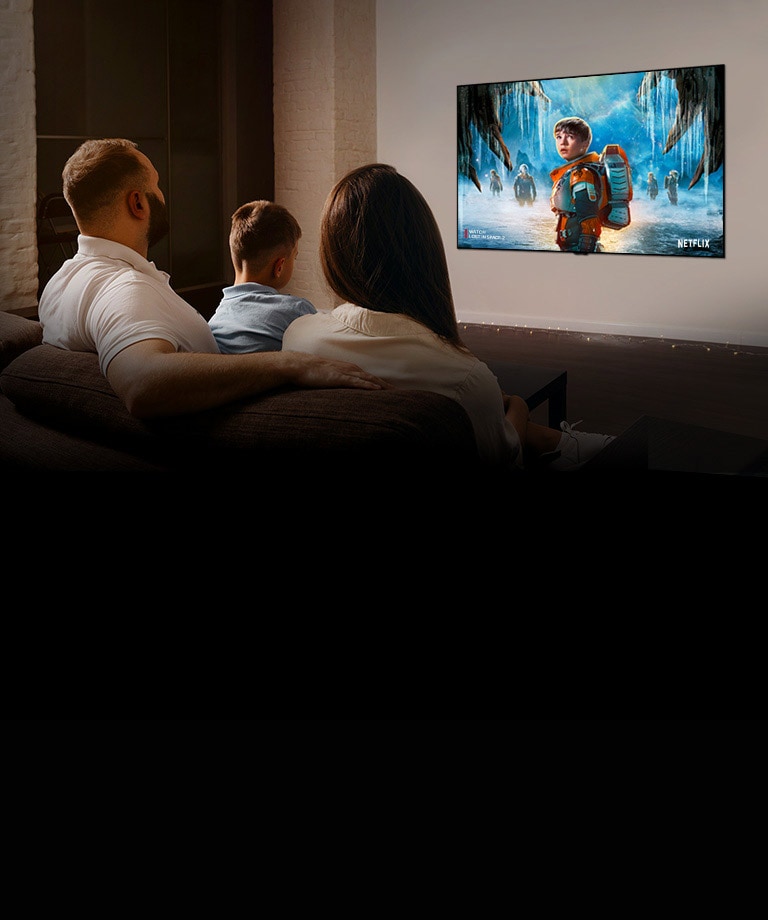 Pareja sentada en un sofá en la sala viendo una película romántica en la televisión