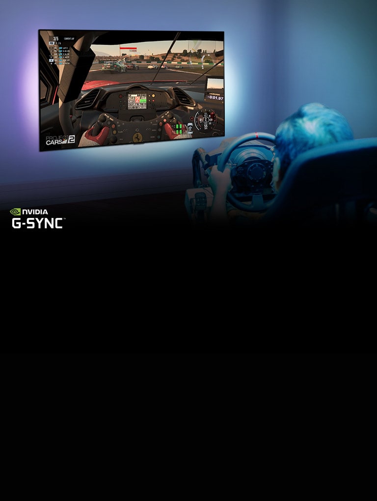 Hombre sentado en una silla de juego de carreras, sosteniendo un volante mientras juega un juego de carreras en una pantalla de TV