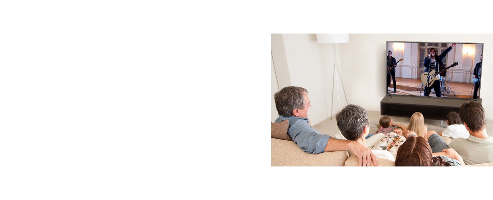 Una familia de siete personas reunida en la sala, viendo una película. La pantalla de TV muestra una banda tocando.