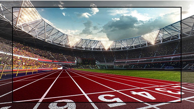 Pantalla de TV que muestra un estadio con una vista de la pista de atletismo de cerca. El estadio está lleno de espectadores.