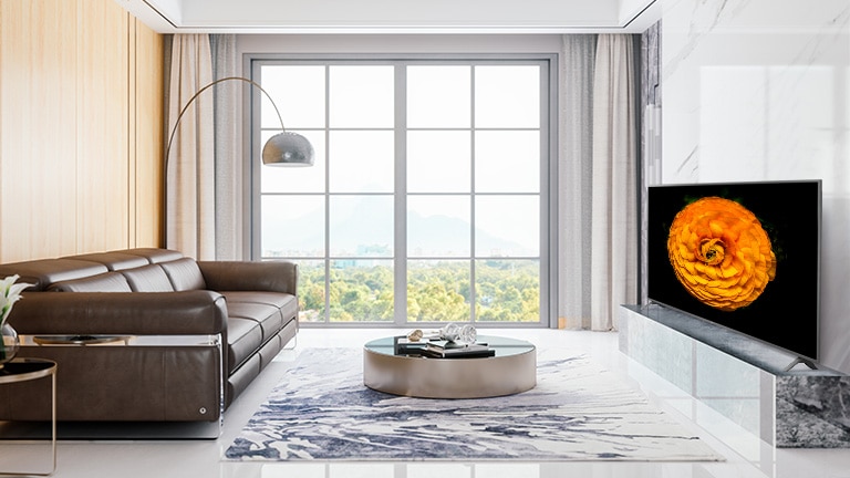 TV LG UHD ubicado en la pared de una sala de estar con el interior minimalista. La imagen de una flor se muestra en la pantalla del televisor.