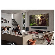 LG 65 pulgadas LG OLED evo AI G5 4K Smart TV 2025, Wide view of a living room inside a premium home, a man is watching a movie on his wall-mounted LG OLED TV. The TV's design blends elegantly with the wall and the interior design., OLED65G5PSA, thumbnail 13