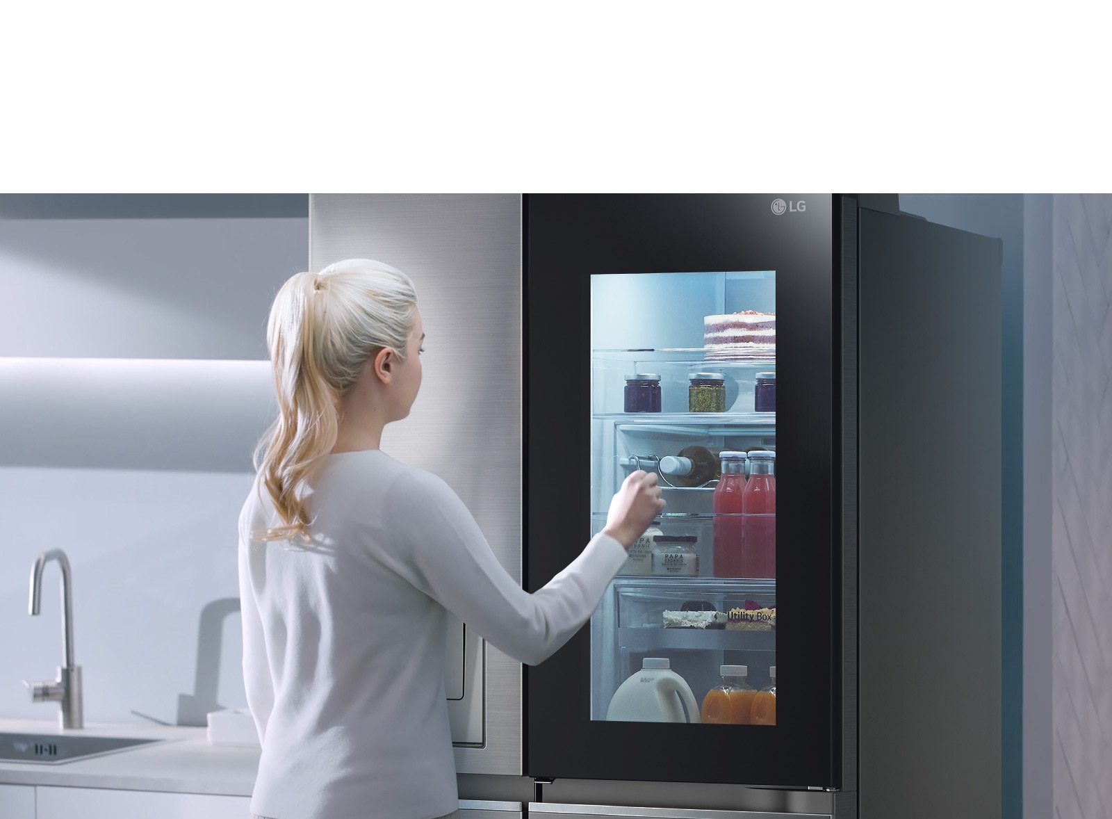 One video shows a woman walking up to her InstaView refrigerator and tapping twice. The interior lights up and you can see the contents of your fridge without opening the door. The view zooms in to focus on the drinks at the door and then zooms out to see the woman from behind as she opens the door and has a drink.