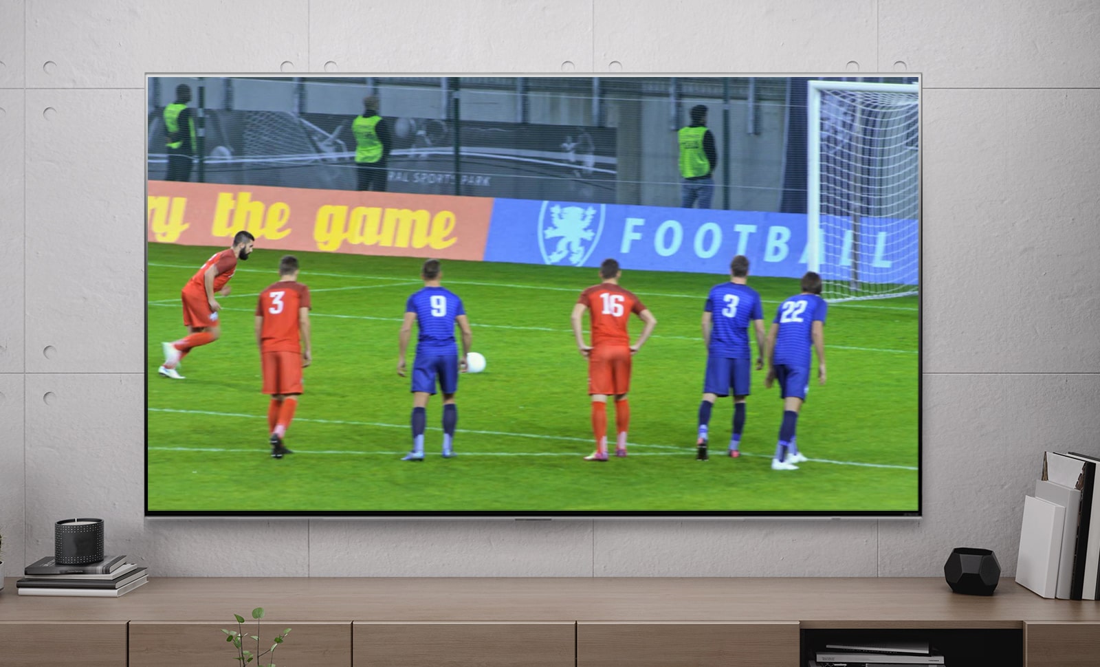 Un écran de téléviseur montre un joueur de football inscrivant un penalty (lire la vidéo).