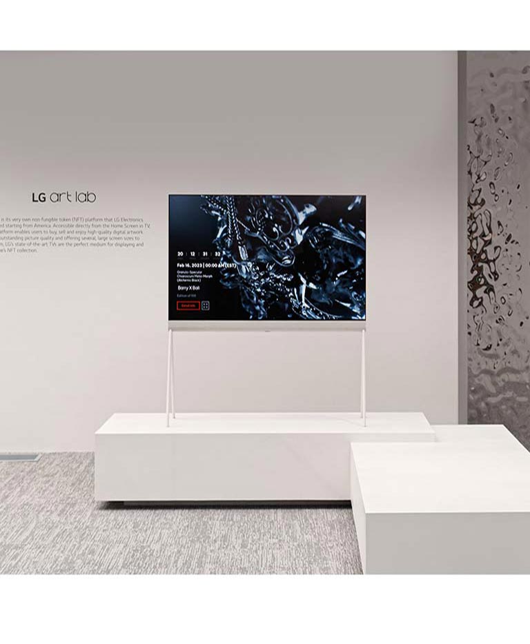 Sur une image du modèle Easel dans une pièce blanche figure une œuvre d’art numérique représentant une sculpture noire à l’écran. Une sculpture matérielle couleur argent sur le côté droit du téléviseur fait apparaître un reflet de la pièce.