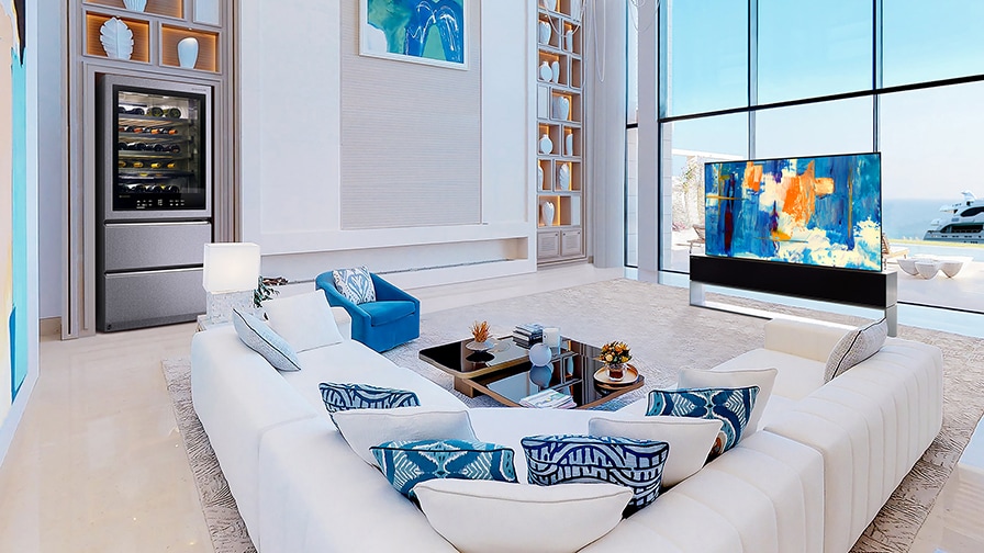 Une télévision OLED R enroulable dans une pièce à dominante bleue devant de grandes fenêtres avec vue sur l'océan.