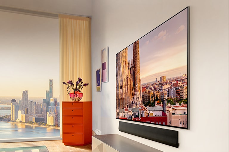 "市景公寓的墙壁上 LG OLED G3 的倾斜视图，下面有一个条形音箱。	"