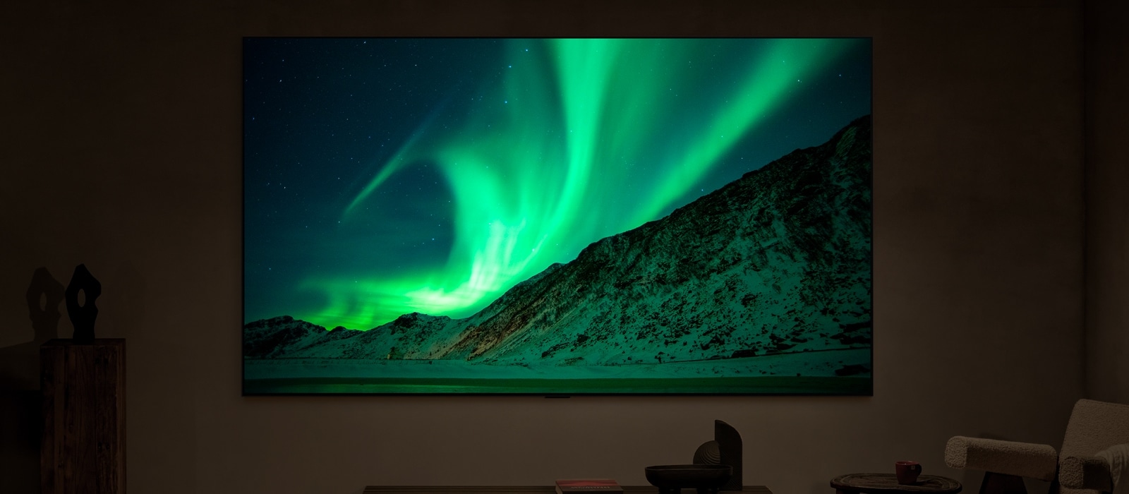 夜晚一个现代化客厅里的 LG TV。标签显示：夜晚。AI Brightness Control 确保电视上北极光的画面以与室内光线相适的亮度水平显示出来