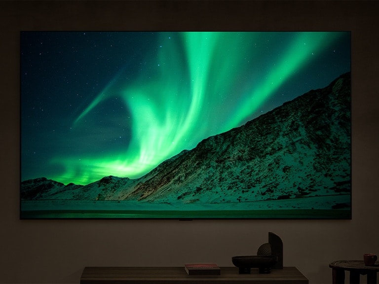 夜晚一个现代化客厅里的 LG TV。标签显示：夜晚。AI Brightness Control 确保电视上北极光的画面以与室内光线相适的亮度水平显示出来