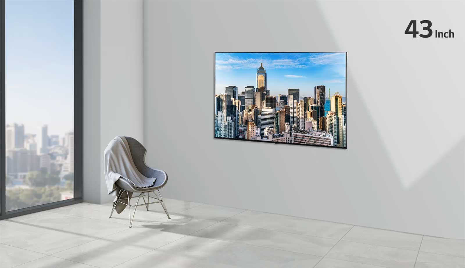 安装在灰色墙壁上的平板电视，旁边是从地板延伸至天花板的落地窗户和一张椅子。屏幕显示蓝天下的城市景观，电视尺寸从55英寸增加到86英寸。