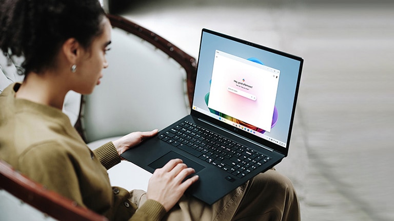 这张图片展示了一位用户正在使用笔记本电脑，屏幕显示丰富多彩的界面，并包含了关于电池续航时间的提示信息。