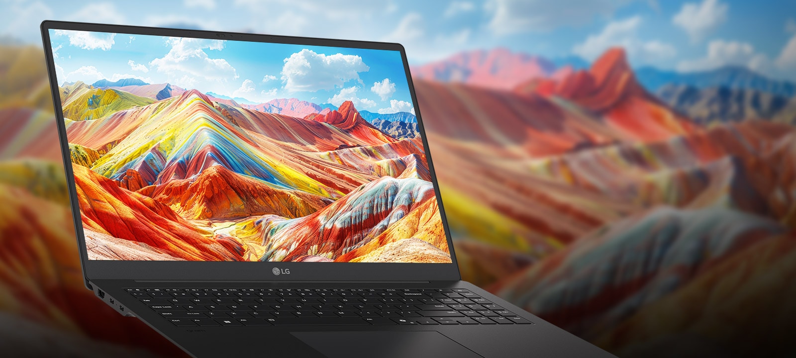 A laptop displaying a vivid and colorful landscape of vibrant mountains on its screen, emphasizing high-resolution and rich color reproduction. The background features a blurred version of the same landscape, drawing attention to the screen quality.	