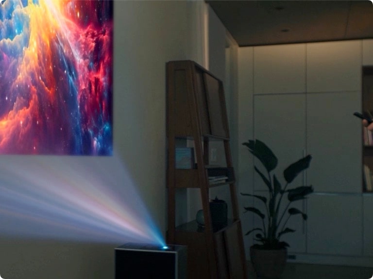 LG CineBeam projecting a galaxy image onto a wall.	